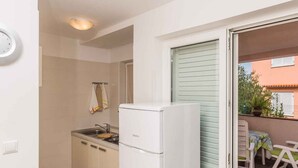 Eine kleine Küche mit Kühlschrank, Spüle und Arbeitsfläche.