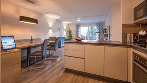 Una cocina moderna con comedor, suelo de madera y un ventanal grande.