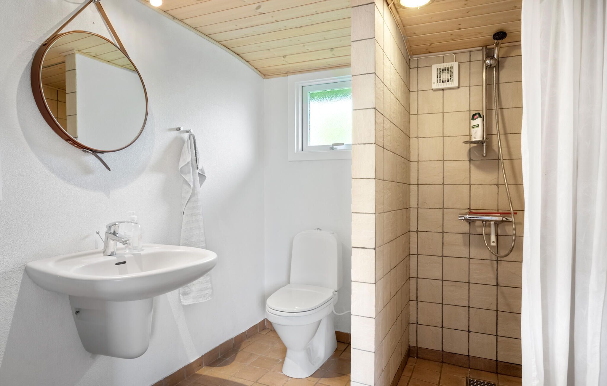 A bathroom with a sink, toilet, and shower.
