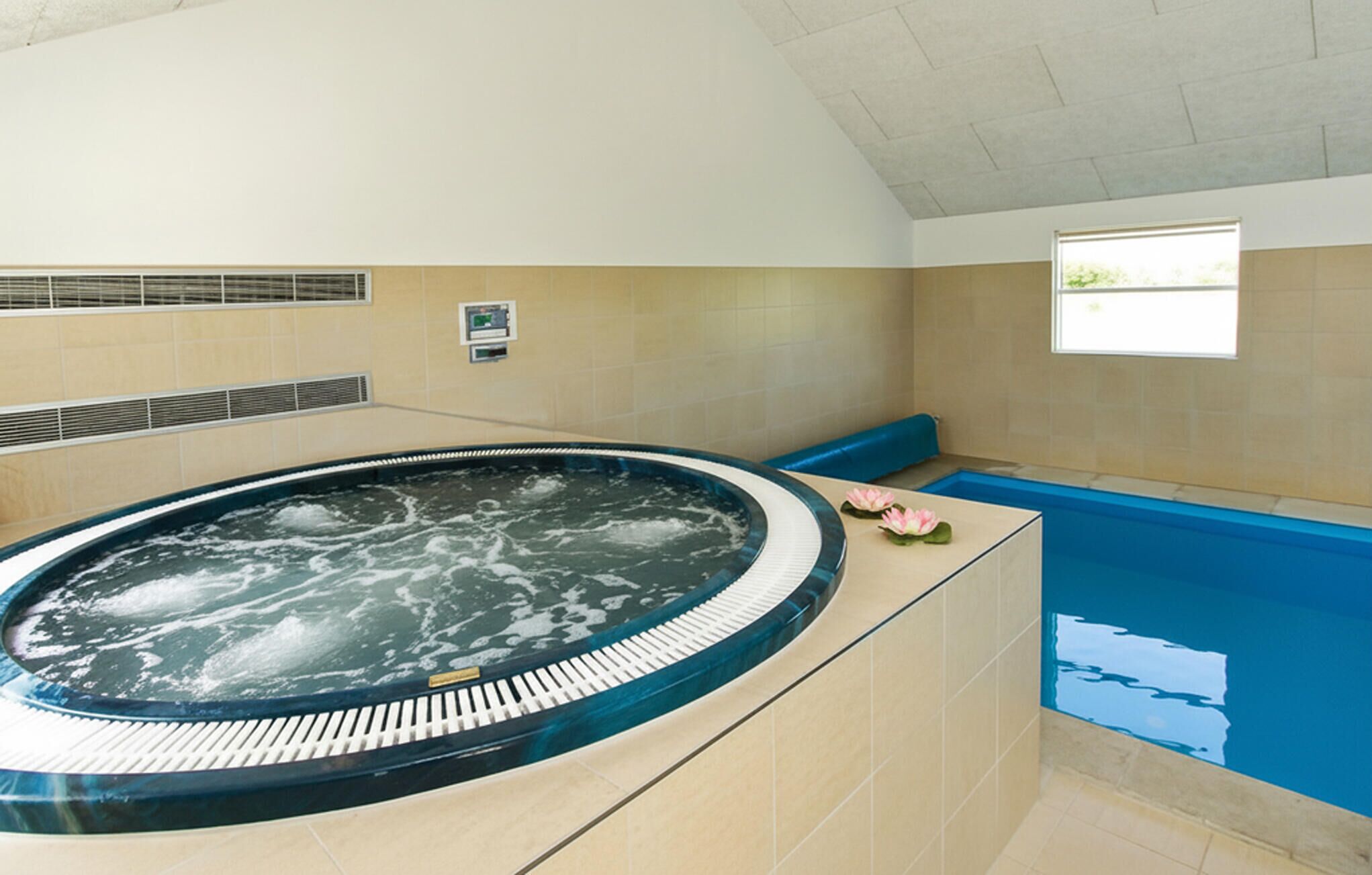 Ein Whirlpool mit Bedienfeld, ein Fenster mit Aussicht und ein gefliester Boden.