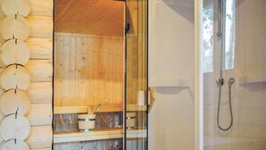 L’intérieur d’un chalet en bois comprend un sauna, une porte en verre et un espace douche.