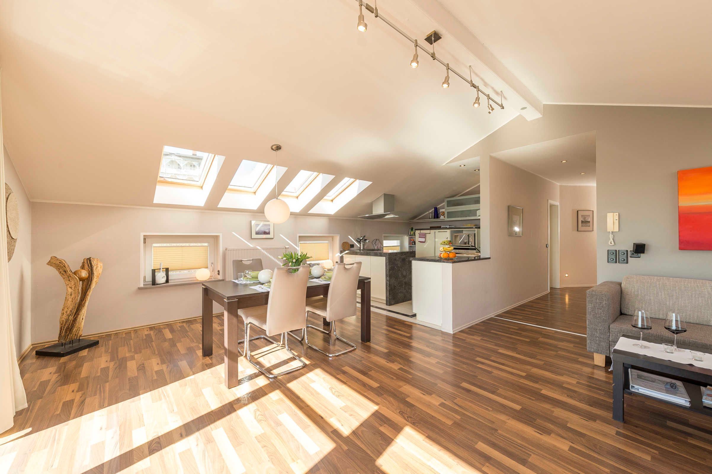 Eine moderne Wohnung mit Essbereich, Küche und Wohnraum, ausgestattet mit Oberlichtern und Holzböden.