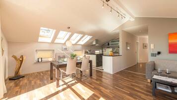 Eine moderne Wohnung mit Essbereich, Küche und Wohnraum, ausgestattet mit Oberlichtern und Holzböden.