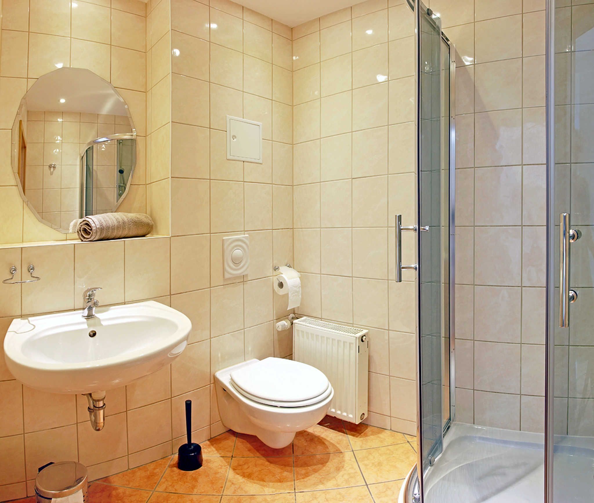Een badkamer met een wastafel, toilet en douchecabine met glazen wanden.