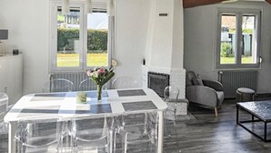 A dining area with a table and chairs, a sofa, and a fireplace.