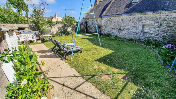 A stone house with a garden, outdoor seating, and a swing set. - 3 bedroom amazing home in Riantec (Riantec)