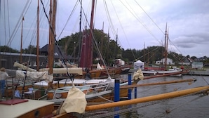 A marina with several boats docked, wooden structures, and a building in the background.