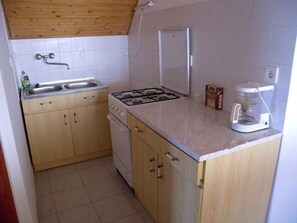 Een koelkast, een oven, een kookplaat, een koffiezetapparaat/waterkoker