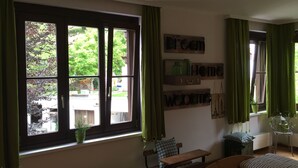 A room with a large window, a bench, a bed, and a wall-mounted shelf with decorative items. - Ferienwohnung Kaffeewerkstatt - Apartments in the coffee shop (Sankt Wolfgang im Salzkammergut)