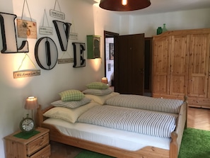 Ein Schlafzimmer mit einem Bett, einem Nachttisch, einer Wanduhr und motivierenden Wandbildern.