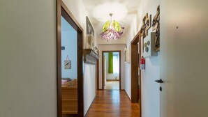 A hallway with wooden flooring, a chandelier, and wall-mounted decorations. - Ferienwohnung Kaffeewerkstatt - Apartments in the coffee shop (Sankt Wolfgang im Salzkammergut)