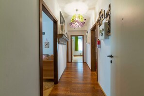 A hallway with wooden flooring, a chandelier, and wall-mounted decorations. - Ferienwohnung Kaffeewerkstatt - Apartments in the coffee shop (Sankt Wolfgang im Salzkammergut)