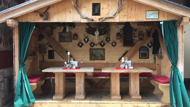 A wooden cabin with a pitched roof, a table with a candle, and antlers on the walls. - Ferienwohnung Kaffeewerkstatt - Apartments in the coffee shop (Sankt Wolfgang im Salzkammergut)