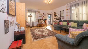 A cozy living room with a sofa, a coffee table, and a rug. - Ferienwohnung Kaffeewerkstatt - Apartments in the coffee shop (Sankt Wolfgang im Salzkammergut)