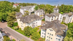 A residential area with multi-story buildings, a road, and greenery. - Vacation apartment 1.2.14 Inselstrand - Holiday apartment 1.2.14 (Heringsdorf)
