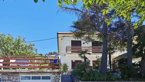 Um edifício de dois andares com uma escadaria de pedra que leva a uma porta de garagem branca.
