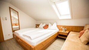 Un dormitorio con una cama de madera, una mesita de noche y un armario de madera.