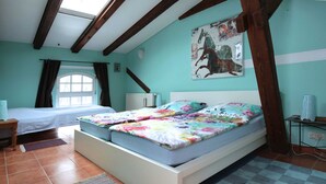 Une chambre à coucher avec un lit, une fenêtre, un radiateur et un tableau accroché au mur.