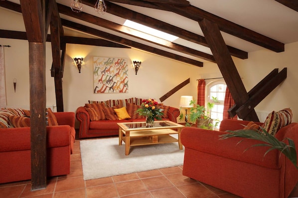Ein Wohnzimmer mit roten Sofas, einem Holztisch und einem Bild an der Wand.