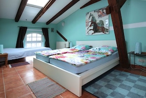 Ein Schlafzimmer mit einem Bett, einem Fenster, einer Heizung und einem Bild an der Wand.