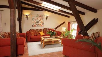 Ein Wohnzimmer mit roten Sofas, einem Holztisch und einem Bild an der Wand.