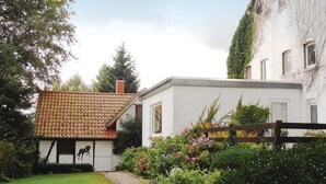 A traditional house with a tiled roof, a small garden with flowers, and a wooden fence. - 2 bedroom nice home in Schwalenberg (Schwalenberg)