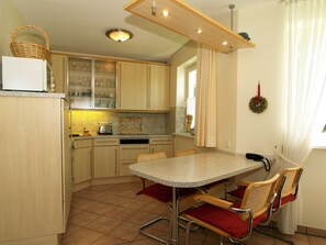 Une cuisine de taille réduite comprenant une table à manger, des chaises et un réfrigérateur.