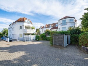Ein Wohngebiet mit mehrstöckigen Häusern, einer gepflasterten Auffahrt und einem verschlossenen Eingang.
