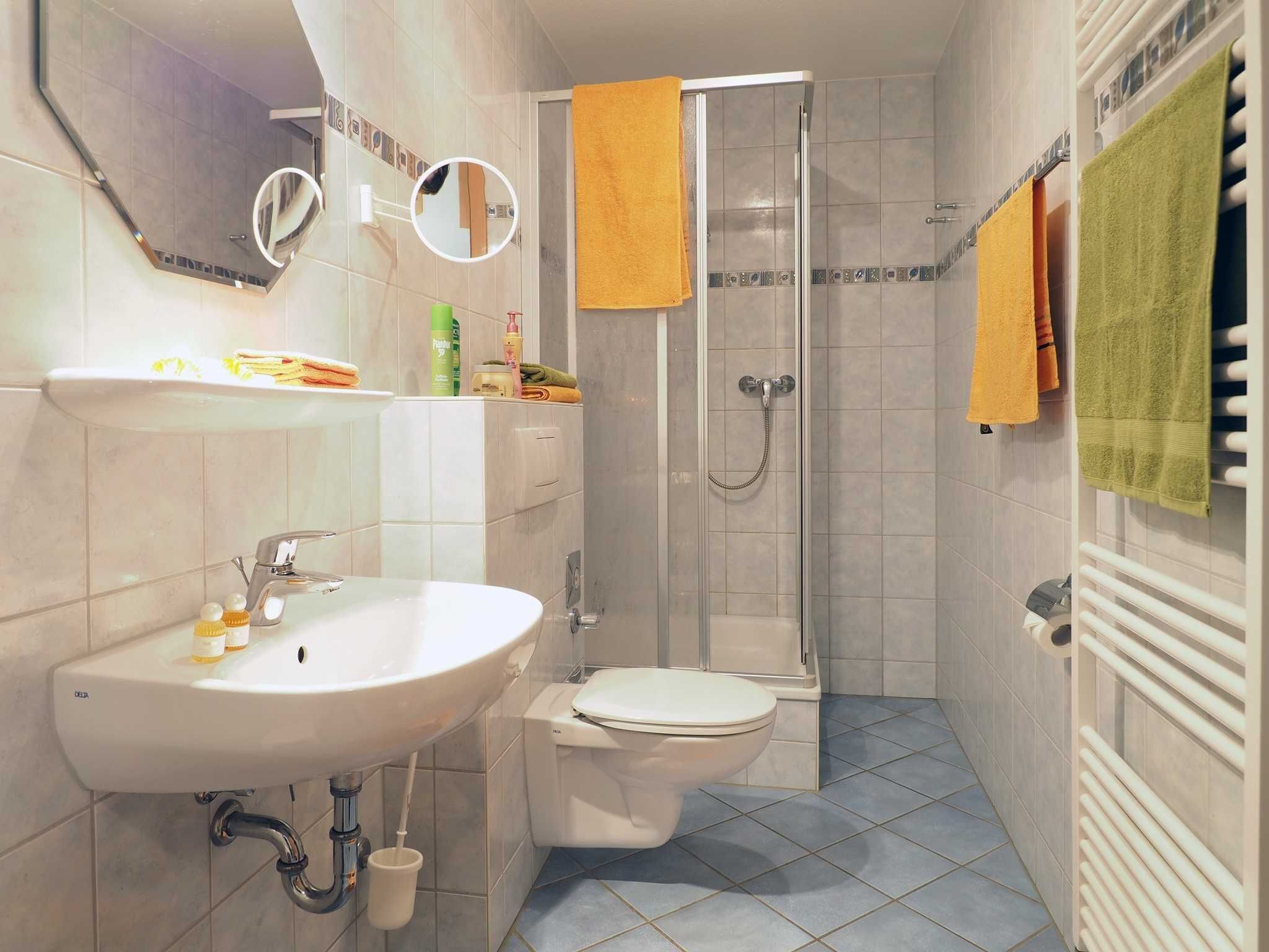 Een badkamer met een wastafel, toilet en douche.