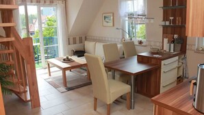 Une cuisine chaleureuse avec un coin repas, des meubles en bois et une vue sur l’extérieur.