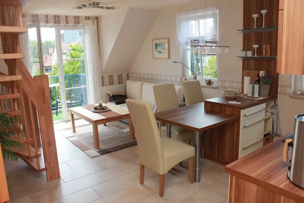 Une cuisine chaleureuse avec un coin repas, des meubles en bois et une vue sur l’extérieur.