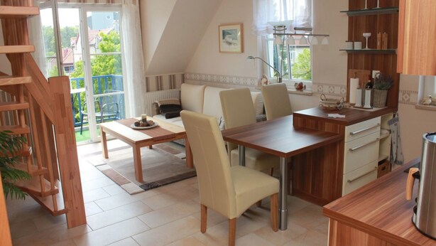 Une cuisine moderne avec un coin repas, des meubles en bois et une vue sur l’extérieur.