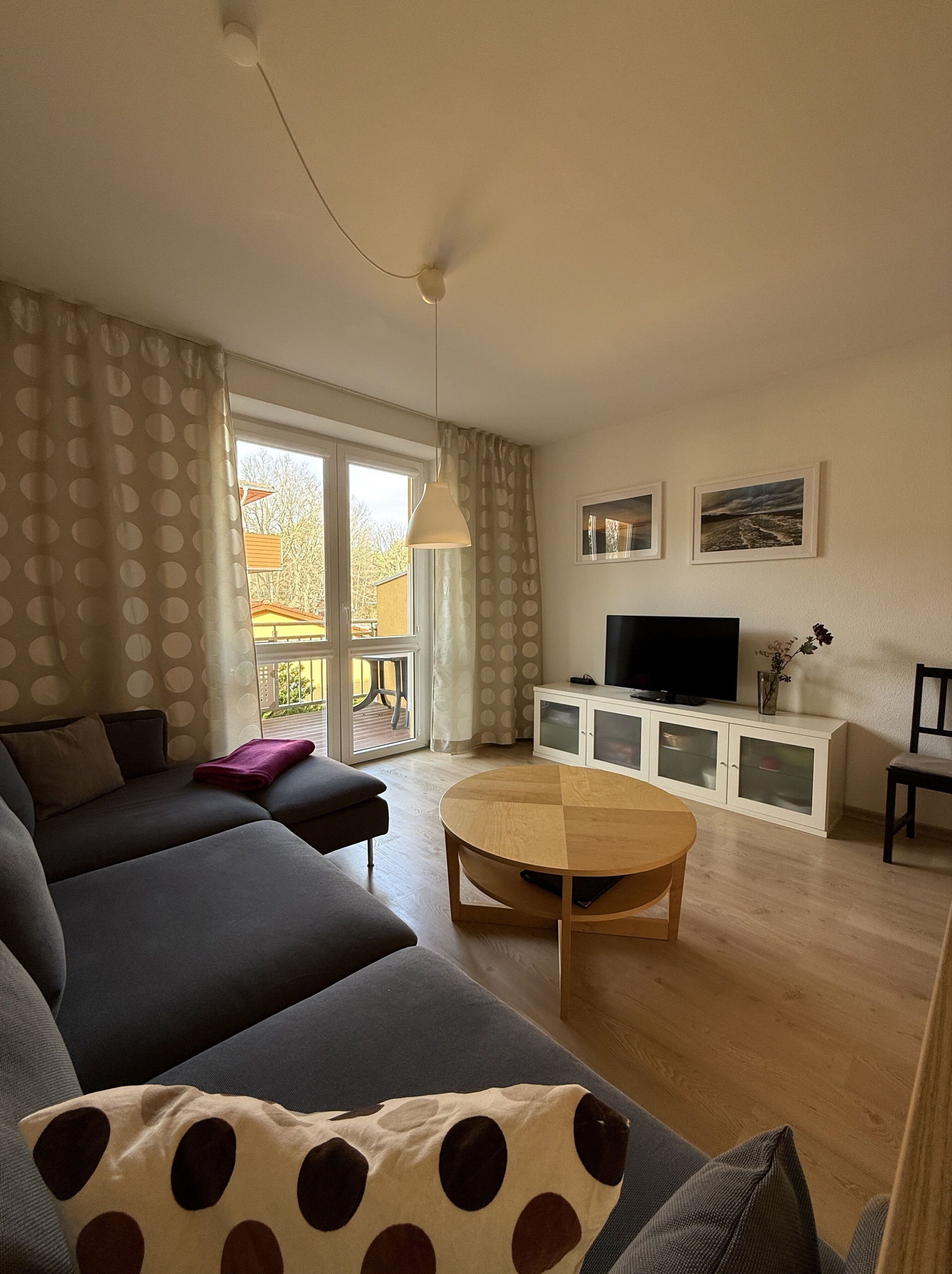 A living room with a sofa, a coffee table, a TV, and a cabinet.
