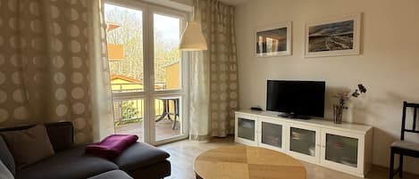 A living room with a sofa, a coffee table, a TV, and a cabinet.