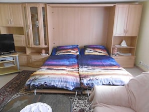 A bedroom with two beds, a TV, and built-in wardrobes. - Old fisherman's house, Germany (Mönkebude)
