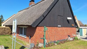 A house with a steep thatched roof, a brick facade, and a chimney. - Old fisherman's house, Germany (Mönkebude)