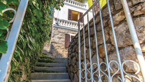 Un escalier en pierre menant à un bâtiment doté d’un balcon.