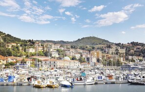 A marina with numerous boats docked, surrounded by a densely packed hillside town with buildings of various architectural styles. - Nice apartment in Imperia IM (Imperia IM)