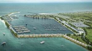 An aerial view of a marina with multiple docks, a large open water area, and a residential area with houses along the waterfront. - Amazing home in OstseeResort Olpenitz with sauna (OstseeResort Olpenitz)