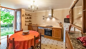 Cocina compacta con comedor, estufa a gas, microondas y refrigerador.