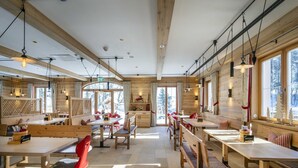 A spacious dining area with wooden tables and benches, large windows, and a high ceiling. - Single room - Berghotel Sudelfeld (Bayrischzell)