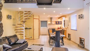 A modern living room with a staircase, a dining area, and a kitchen. - 2 bedroom amazing home in LA HAGUE (LA HAGUE)