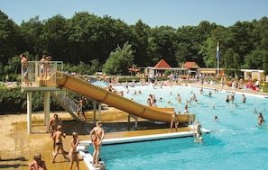 A swimming pool with a slide, surrounded by trees and shaded areas. - Cozy home in Vledder with WiFi (Vledder)