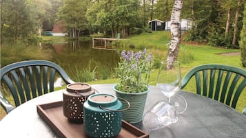 A table with a tray, two ceramic containers, a potted plant, and a wine glass.