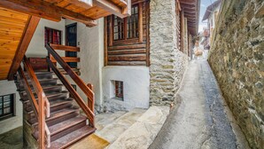 Une ruelle étroite aux murs de pierre et aux bâtiments en bois.