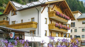 A hotel with a white facade, wooden balconies, and flower boxes. - gemuetliche Ferienwohnung (Kappl)