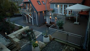 A residential building with a balcony, outdoor seating area, and potted plants.