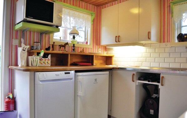 A compact kitchen with a dishwasher, a stove, and a microwave.