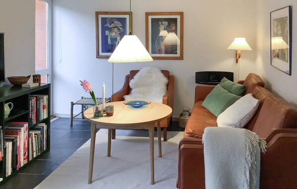 Relax in this inviting living room with a comfortable sofa, bookshelf, and floor lamp.