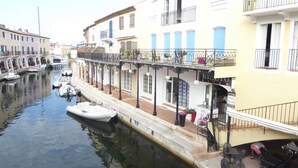 A canal with boats, a restaurant with outdoor seating, and buildings with balconies. - House - House btw. Cogolin and St. Tropez (Cogolin)
